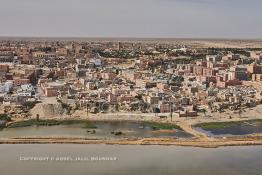 Image du Maroc Professionnelle de  Cette vue aérienne de la ville de Laayoune nous découvre au premier plan le fleuve la Sakia Al Hamra juste derrière protégé par une digue la partie stagnante des égouts à ciel ouvert, malgré tous les investissements la ville manque cruellement d'une station de pompage et d'une station de traitement des eaux usées, le 9 Avril 2010. (Photo / Abdeljalil Bounhar) 